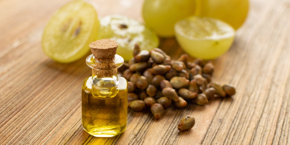 grape seeds, grapes, and grapeseed oil on a wooden table