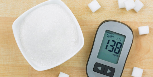 bowl of artificial sweeteners next to a blood sugar monitor